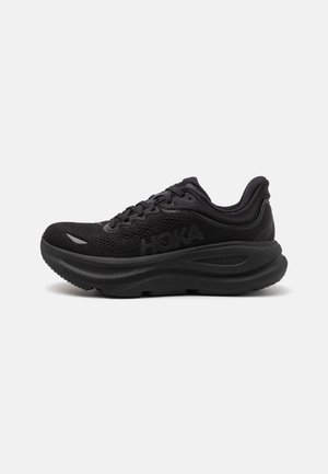 Czarne sportowe buty z siateczkowym cholewką, sznurowanym zapięciem, grubą podeszwą środkową i teksturowaną podeszwą zewnętrzną. Posiadają widoczne logo z boku.