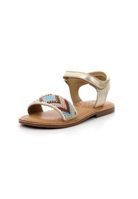 Sandalias de cuero dorado con parte superior de cuentas que presenta patrones en rojo, azul y blanco. Diseño de punta abierta con correa ajustable en el tobillo. Suela plana.