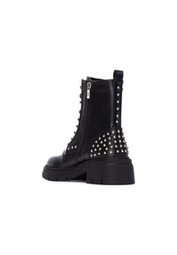 Botas de cuero negras hasta el tobillo con cremallera lateral, detalles de tachuelas en el tacón, suela gruesa y diseño de punta redondeada. Acabado texturizado.
