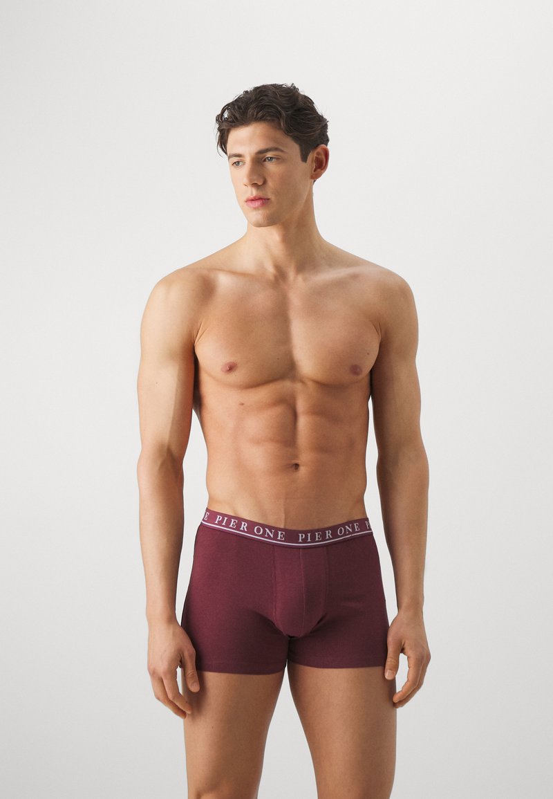 Bordeauxfarbene Boxershorts aus weichem Stoff mit glatter Textur, ausgestattet mit einem kontrastierenden, markierten Taillenbund.