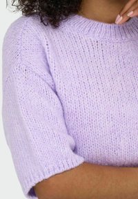 Maglione a maglia di colore viola chiaro con maniche corte, caratterizzato da un colletto a coste e una texture morbida. Variazioni sottili nel colore del filato.