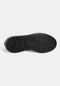 Schwarze Gummisohle mit strukturiertem Profil. Verfügt über horizontale und vertikale Rillen für besseren Halt. Flaches und robustes Design.