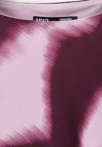 Primo piano di un tessuto di seta con motivi astratti di pennellate in morbido rosa e viola intenso.