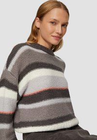 Sweter w robionym na drutach kroju typu cropped, z poziomymi paskami w kolorach szarym, białym i delikatnym różowym. Okrągły dekolt i prążkowany dół dodają faktury.