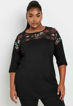 Czarny long sleeve top z przezroczystym, haftowanym dekoltem z siateczki, ozdobionym czerwonymi i białymi kwiatowymi wzorami. Miękka tkanina, luźny krój.