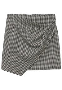 Falda con patrón de pata de gallo en blanco y negro, diseño delantero drapeado, con cinturilla sólida y dobladillo asimétrico. Tejido texturizado.