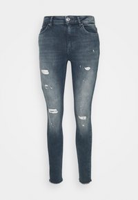 Jeans ajustados en denim de lavado oscuro, con elementos desgastados, desgarros en las rodillas, cierre de botón, cinco bolsillos y dobladillos deshilachados.