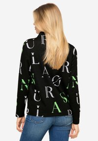 Schwarzer Pullover mit großen, kontrastierenden Buchstaben in Grau und Grün. Lange Ärmel mit lockerer Passform, strukturierter Stoff. Rückansicht gezeigt.
