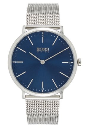 Sølv mesh remur med blå urskive, tynde sølv time- og minutviser samt "BOSS HUGO BOSS" logo ved kl. 12.