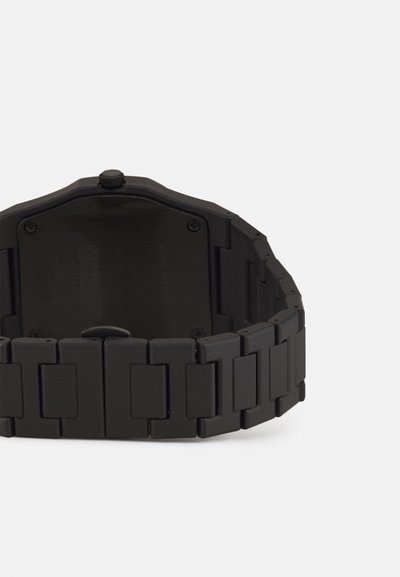 Μαύρο ρολόι με ματ φινίρισμα, οκταγωνική κάσα και αλυσίδα. Διαθέτει απλή πλάτη με ελάχιστες λεπτομέρειες και κορώνα στο πλάι.