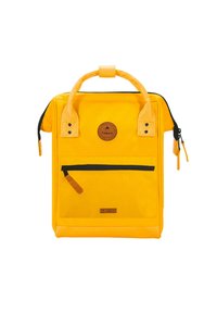 Gelbe Rucksack in rechteckiger Form, mit Lederakzenten, einer vorderen Reißverschlusstasche und einem runden Logo-Patch. Reißverschluss- und Griffdetails sichtbar.