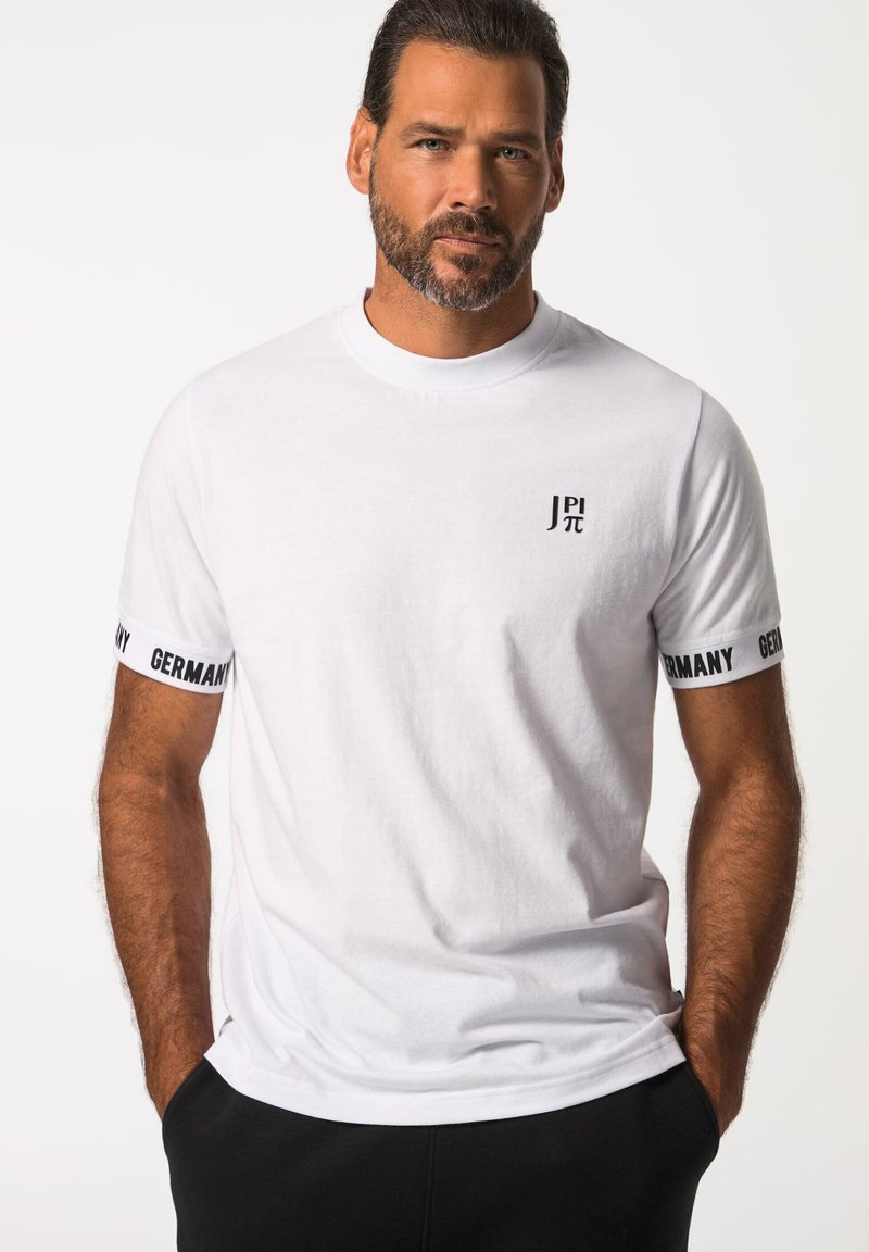 Valkoinen puuvillapaita, jossa on pyöreä kaula-aukko, ja joissa on mustat tekstit "JP π" ja "Saksa" hihoissa. Rentomallinen, jonka pinta on sileä.