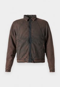 Brown denim jacket with a stand-up collar, zip front, and two side pockets. Features a slightly worn texture and elastic cuffs.