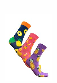 Trois paires de chaussettes en coton : bleu marine avec des motifs d'ananas et des poignets orange, rose avec des bananes jaunes, violet avec des ananas jaunes.