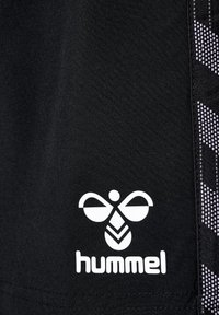 Svarta träningsshorts i slät tyg med en framträdande vit logotyp och en geometrisk design i grått längs sidan.