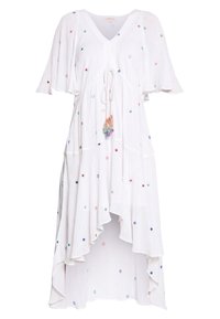 Robe blanche à ourlet asymétrique avec manches flottantes, petits motifs circulaires multicolores et taille à cordon avec pompons multicolores.