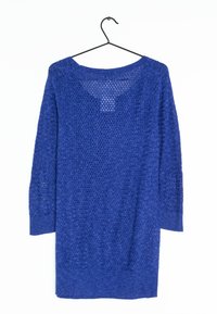 Niebieski, długi sweter dziany z ażurowym wzorem, wiszący na czarnym drucianym wieszaku na białym tle.