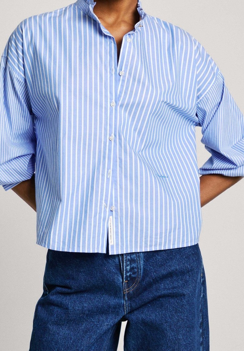 Blue and white striped button-up shirt with a mandarin collar and wide sleeves; made of light fabric with a smooth texture.