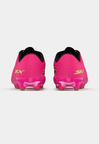Bright pink soccer cleats with a smooth texture, featuring a sleek design and transparent outsole with green studs. Black inner lining visible.