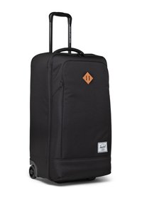 Černý kufr na kolečkách s měkkým vnějším povrchem, horním uchem, teleskopickou rukojetí a koženým akcentem v hnědé barvě. Disponuje jednoduchým, elegantním designem.