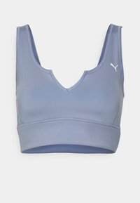 Brassière de sport bleu clair avec larges bretelles, encolure en V et logo Puma sur le côté gauche de la poitrine, conçue pour un soutien athlétique.
