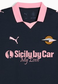 Granatowa koszulka piłkarska z różowym kołnierzykiem i logo. Zawiera różowy napis „Sicily by Car My Love” oraz okrągłe godło Palermo FC. Miękki materiał.