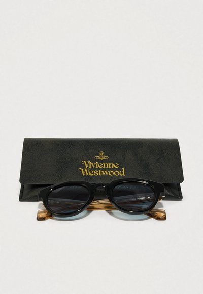 Čierne okrúhle slnečné okuliare s tmavými sklami, so zlatými akcentami na ramienkach, odpočíva na čiernom koženom puzdre so zlatým logom Vivienne Westwood.