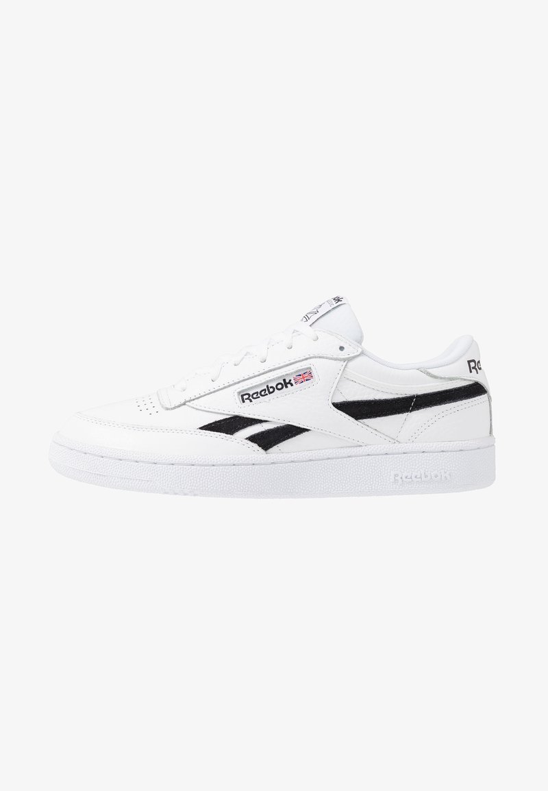 Weiße Leder-Sneaker mit schwarzen Akzenten, ausgestattet mit einem Low-Top-Design, perforiertem Zehenbereich und strukturiertem Gummisohle. Reebok-Logo an der Seite.