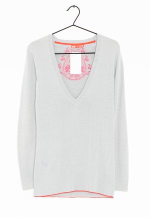 Lysegrå V-hals sweater med lange ærmer, ribkant ved ærmer og bund, lyserødt indvendigt logo, hængende på en sort bøjle mod en hvid baggrund.