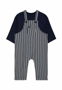 Blaue gestreifte Latzhose mit einem navyfarbenen T-Shirt. Die Latzhose verfügt über große Fronttaschen, verstellbare Träger und umgekrempelte Säume an den Knöcheln.