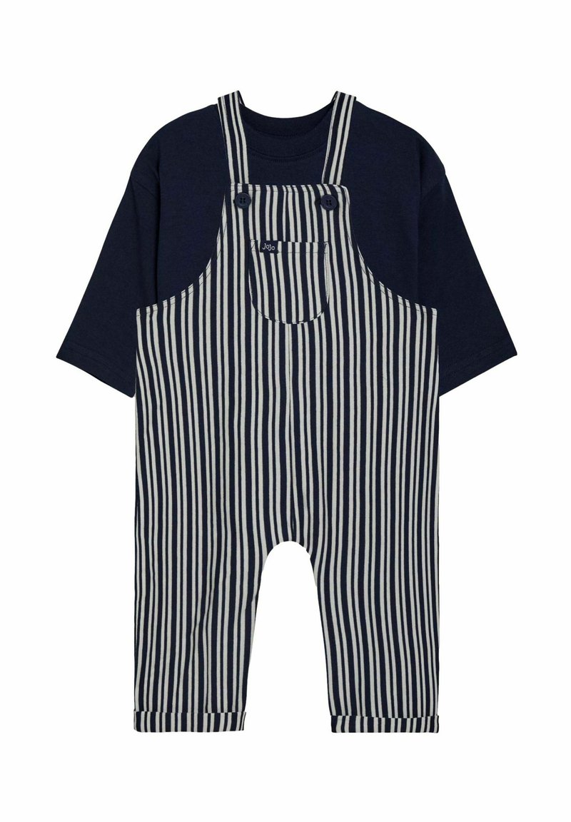 Blaue gestreifte Latzhose mit einem navyfarbenen T-Shirt. Die Latzhose verfügt über große Fronttaschen, verstellbare Träger und umgekrempelte Säume an den Knöcheln.