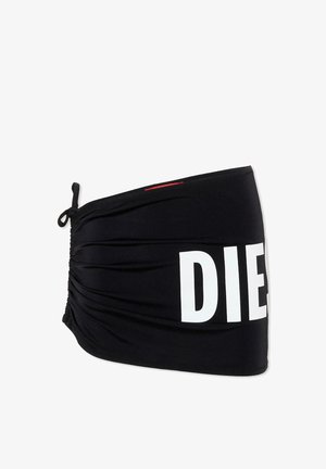 Czarna materiałowa opaska na głowę z regulowanym wiązaniem po jednej stronie oraz dużymi białymi literami "DIE" częściowo widocznymi z przodu.