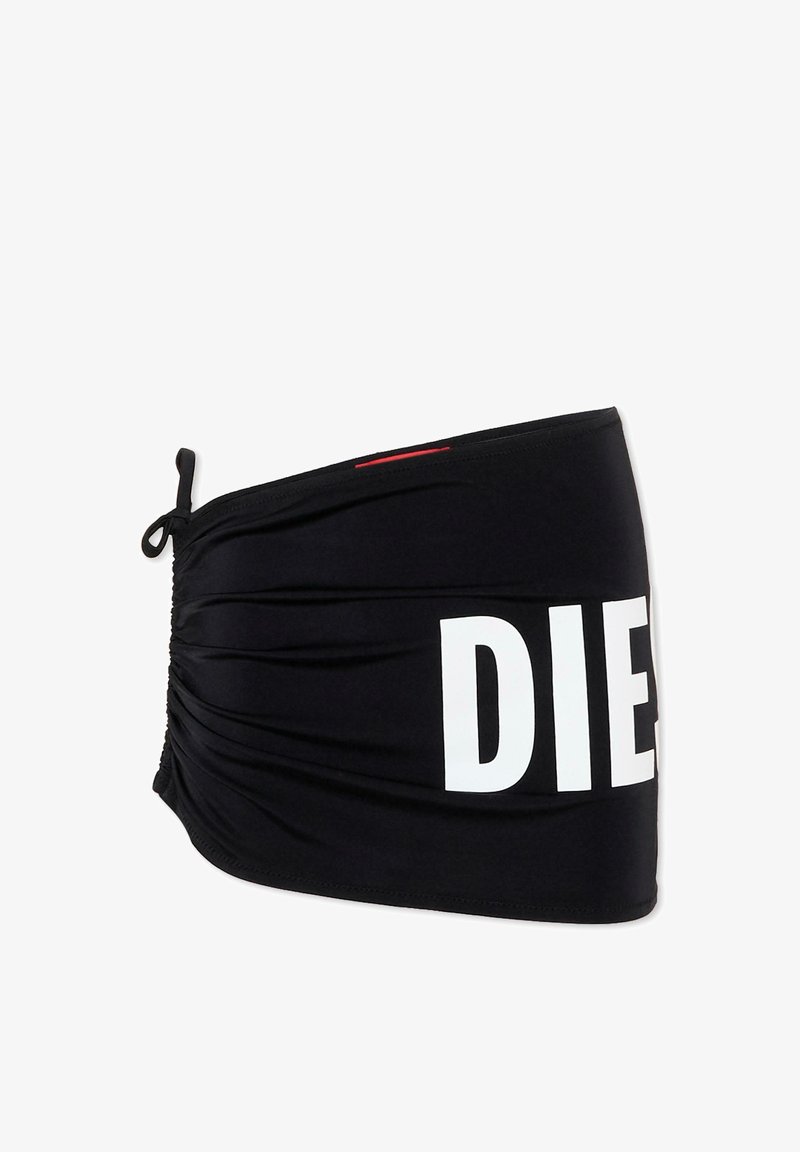 Fascia per capelli in tessuto nero con laccio regolabile su un lato e grandi lettere bianche "DIE" parzialmente visibili sul davanti.