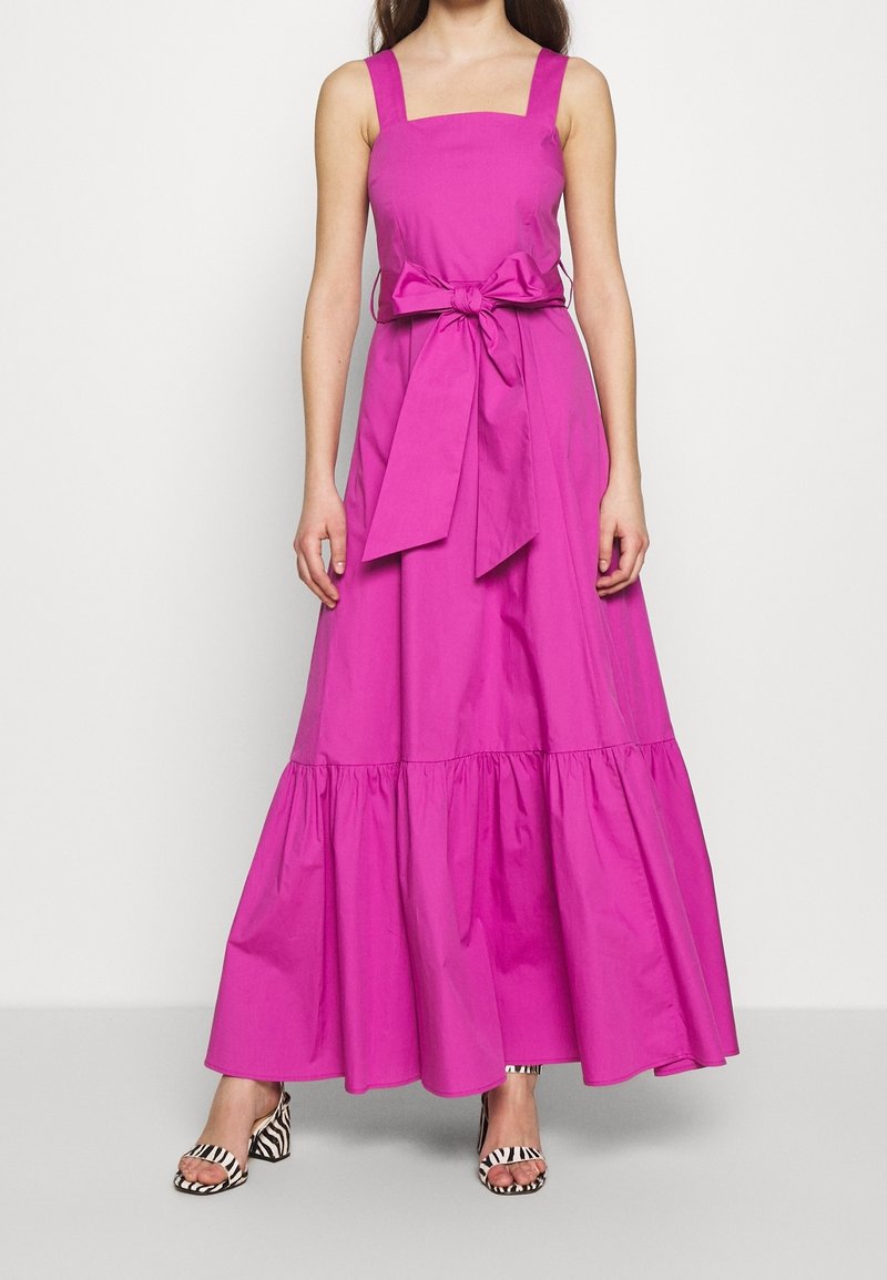 Vaaleanpunainen puuvillainen maksimekko, jossa on neliömäinen pääntie, paksut olkaimet, solmittu vyötärönauha ja levenevä röyhelöhelma. Yhdistetty raitakenkiin.