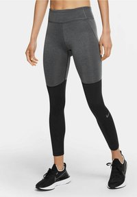 Leggings a vita alta caratterizzati da una combinazione di colori grigio e nero, realizzati in un materiale elastico e traspirante con una texture liscia.