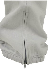 Light grey sweatshirt featuring a front zipper, ribbed hem, and soft textured fabric. Zipper is silver-toned, accenting the design.