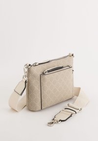 Geantă crossbody din pânză bej, cu un model geometric, accesorii din metal argintiu, două compartimente cu fermoar și o curea ajustabilă.
