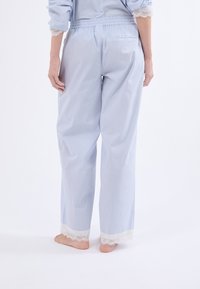 Pantalones de pijama a rayas azul claro con encaje en los puños, cinturilla elástica y un corte holgado, fabricados en un tejido suave y transpirable.