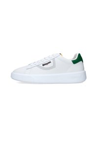 Zapatilla blanca con acabado de cuero liso, acento verde en el talón, detalles perforados y suela gruesa de goma blanca. Presenta texto del logo en el lateral.