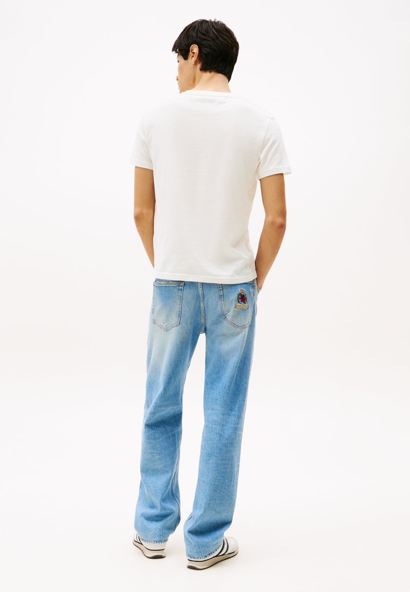 Jasnoniebieskie dżinsy o luźnym kroju, z haftem na tylnej kieszeni. W połączeniu z prostą białą koszulką bawełnianą.