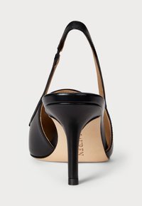 Crne kožne štikle s visokim potpeticama, šiljatog prsta i otvorenom stražnjom stranom. Imaju vitku stiletto potpeticu i svijetlu bež unutrašnjost.