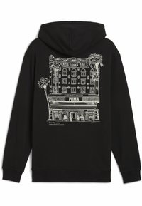 Felpa nera con cappuccio caratterizzata da un'illustrazione in bianco di un edificio con palme, e il testo "PUMA" al centro. Materiale in misto cotone.