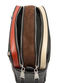 Czarna skórzana torba z czterema zamykanymi na zamek przegródkami; charakteryzuje się czerwonymi, brązowymi, beżowymi i zamszowymi akcentami, srebrną metalową okuciami oraz fakturowaną powierzchnią.