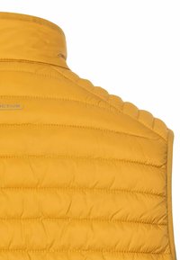 Gul isoleret vest med høj krave, med vandret quiltet design og glat overflade. Logodetaljer synlige nær halsen.
