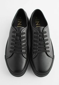 Sneakers negri din piele cu suprafață texturată, vârf rotund și sistem de șireturi cu șase găuri. Prezintă un guler căptușit și o talpă plată din cauciuc.