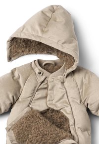 Beżowy, pikowany strój z teksturowanym kapturem podszytym brązowym futerkiem z tworzywa sztucznego, wyposażony w zatrzaski i miękką podszewkę dla ciepła.