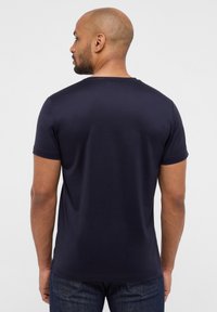 T-shirt blu navy a maniche corte realizzato in morbido cotone, con collo rotondo e design semplice. Leggermente aderente alle spalle.