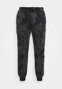 Zwarte joggingbroek met een vlampatroon in donkergrijs. Voorzien van een elastische tailleband met een trekkoord en ribgebreide boorden bij de enkels.