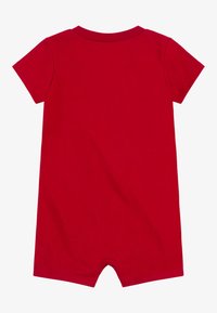 Combinaison rouge à manches courtes en coton doux, avec un col rond et une fermeture à boutons-pression en bas pour un habillage facile.