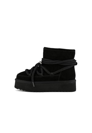 Botas de tobillo de ante negro con suelas de plataforma gruesa, que presentan cordones gruesos y un detalle de cremallera lateral. Superficie texturizada y elementos de diseño en capas.